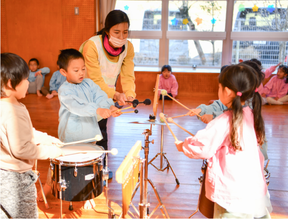 写真:園児4名が太鼓やシンバルなどの楽器を叩いている